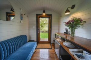 Sofa and kitchen amenities in the Pheasant Shepherds Hut